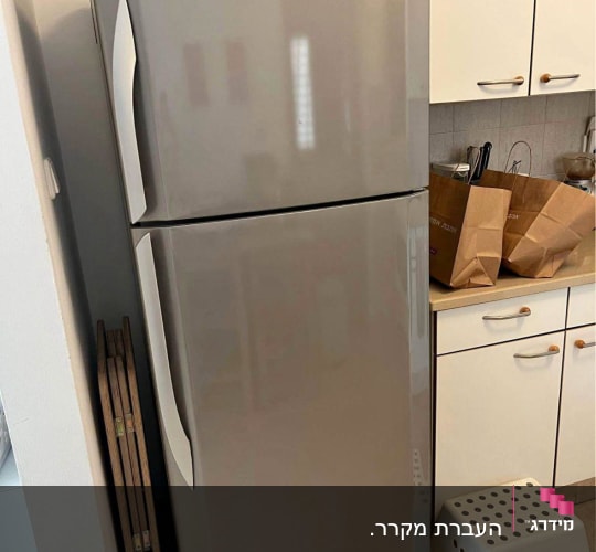 מקרר במטבח עם שקיות נייר ושרפרף לבן